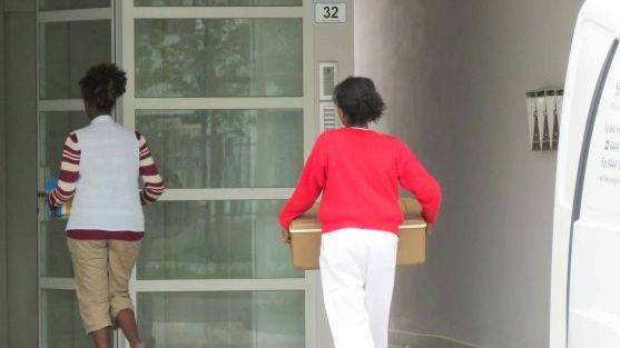 Due donne trasportano il cibo portato dal servizio catering
