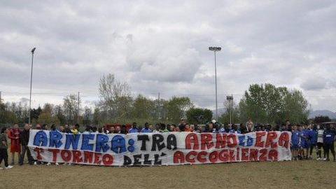 Le squadre in campo con lo striscione