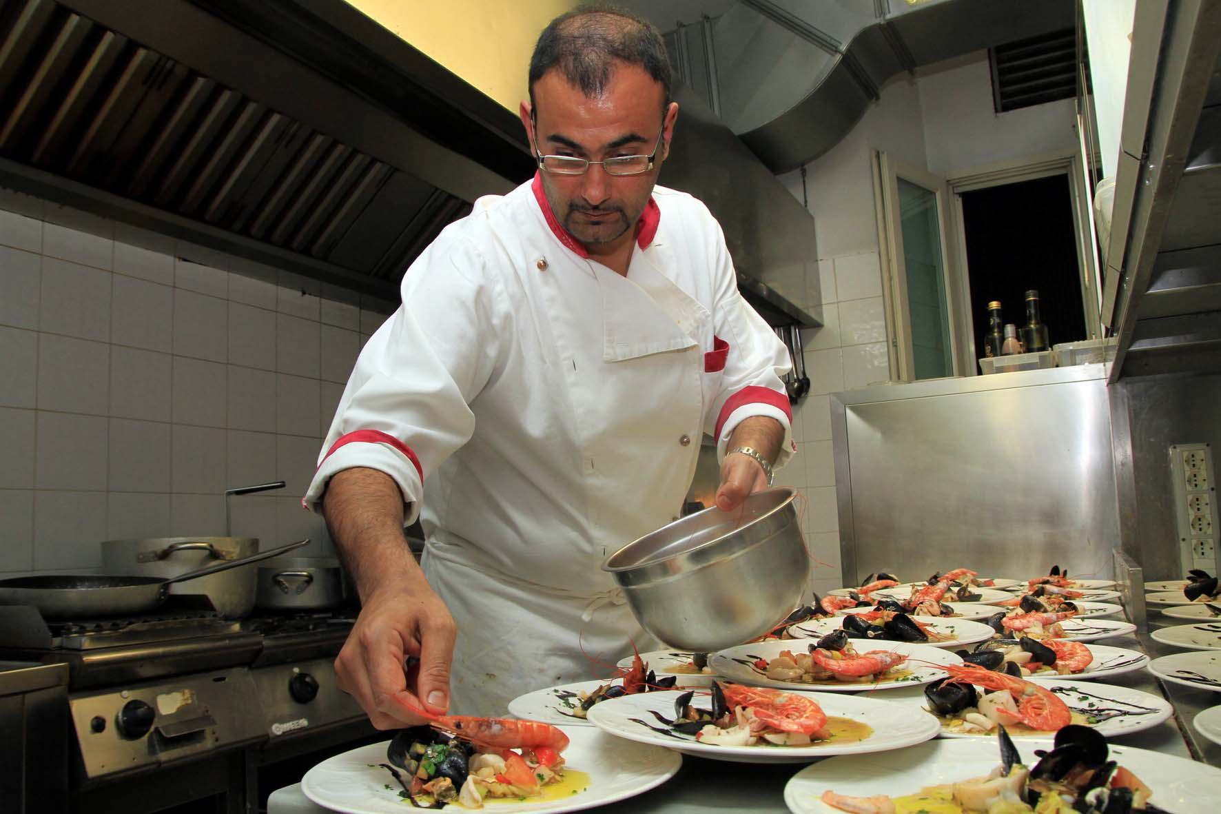 La preparazione di alcuni piatti nella cucina di un ristorante (foto d'archivio)