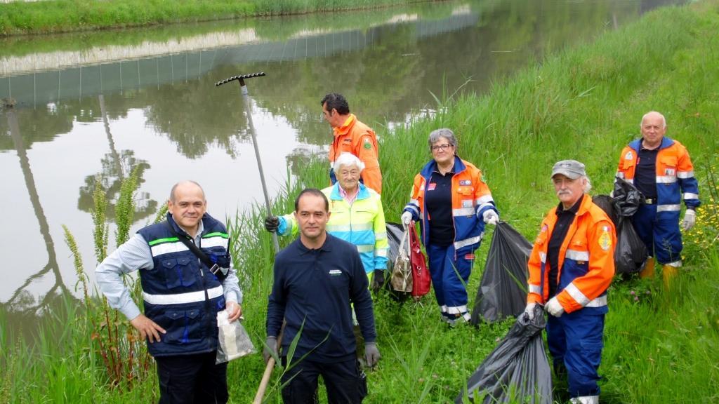 Alcuni volontari e operai al lavoro per la pulizia dei canali