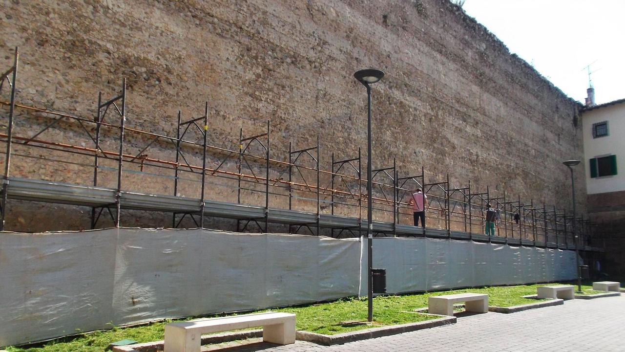 Operai al lavoro sul ponteggio lungo le mura a porta Santa Trinita