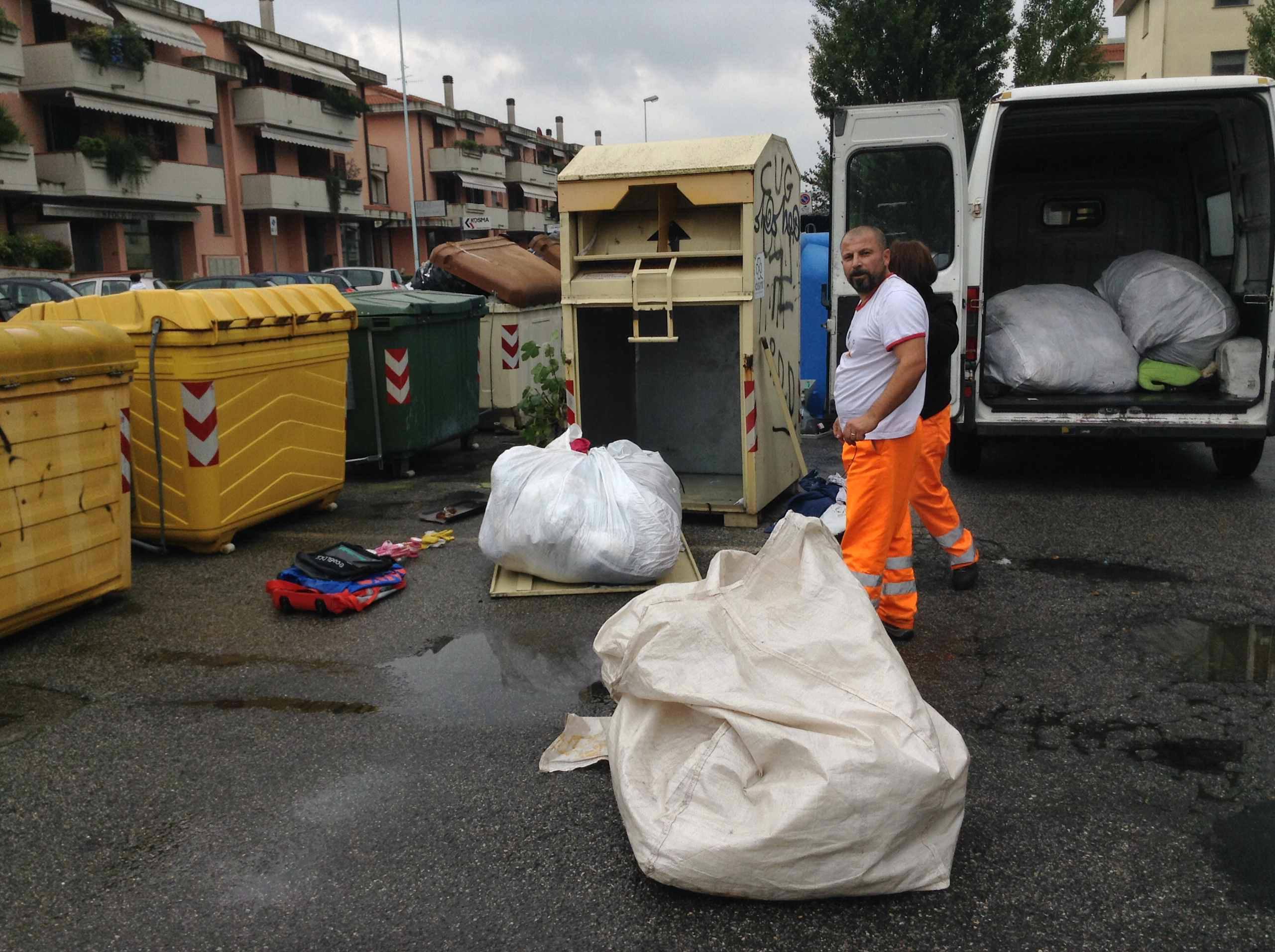 Operatori al lavoro nel ritiro di indumenti usati