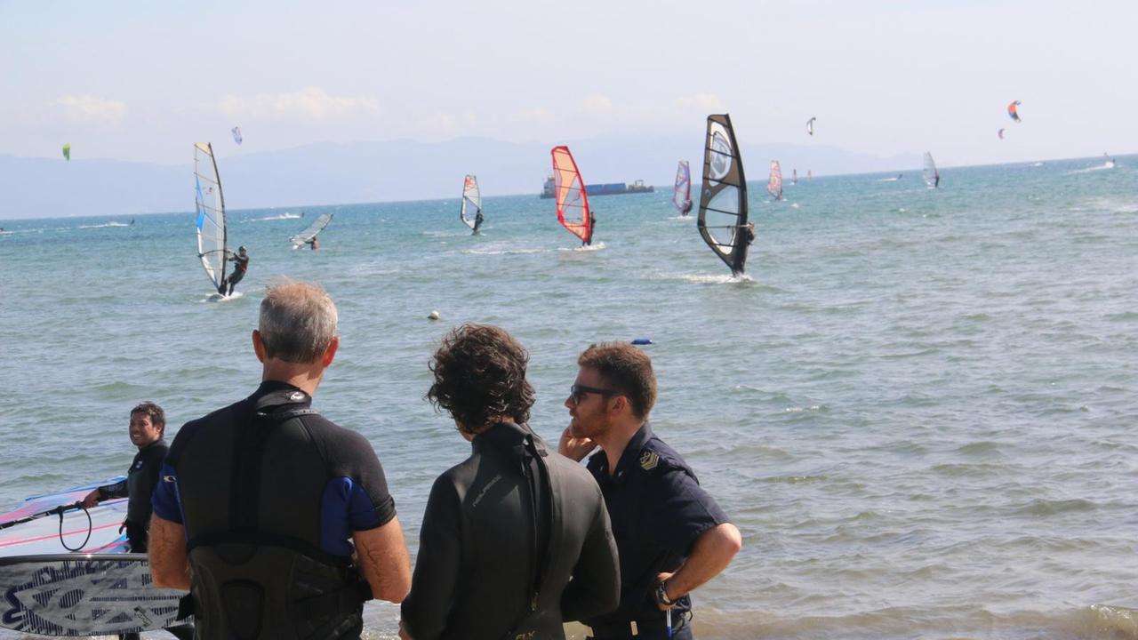 I surfisti e la guardia costiera sulla spiaggia della Fertilia durante le ricerche del disperso (foto Enzo Russo)