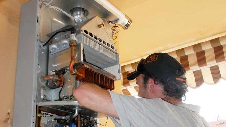 Un tecnico a lavoro su una caldaia a metano