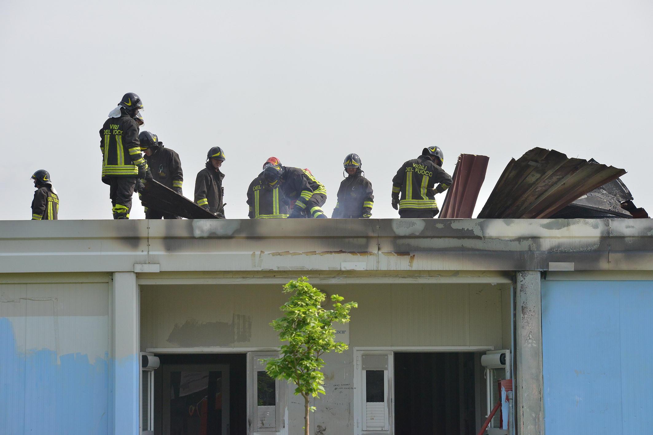 I vigili del fuoco sul tetto dell'edificio scolastico dove è scoppiato l'incendio (foto Sestini)