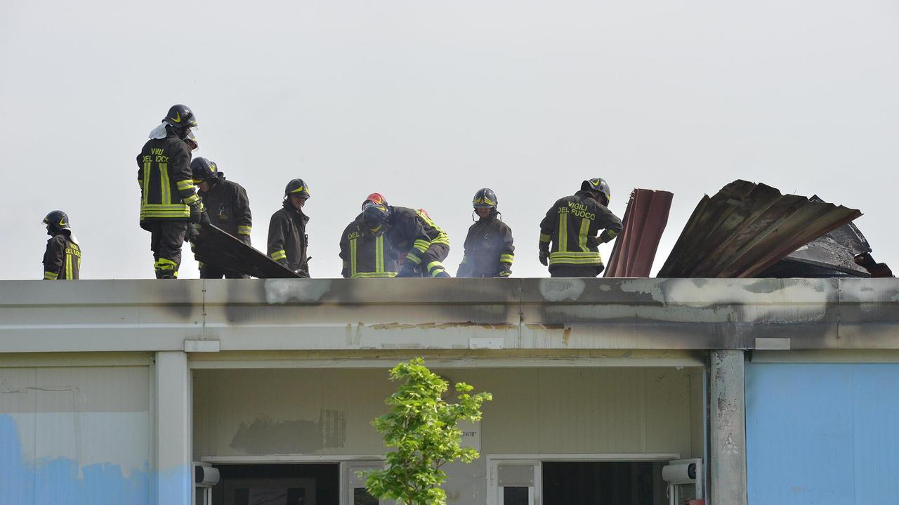 I vigili del fuoco sul tetto dell'edificio scolastico dove è scoppiato l'incendio (foto Sestini)
