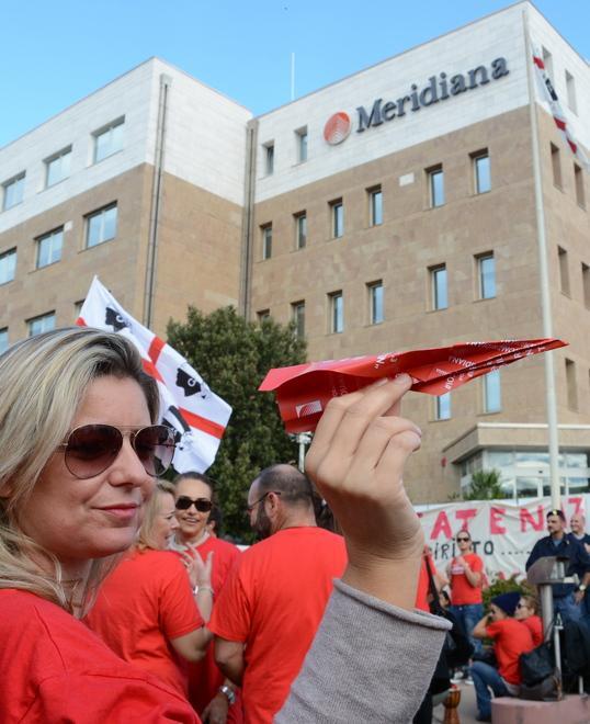 Un'assistente di volo di Meridiana davanti alla palazzina della compagnia a Olbia