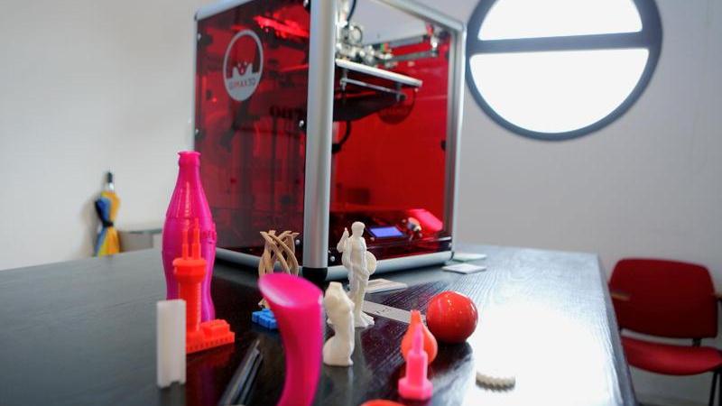 Una stampante in 3D e gli oggetti prodotti