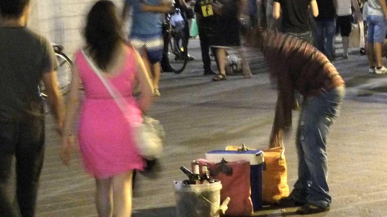 Un venditore abusivo di birre in centro