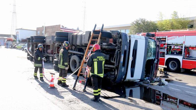 Il camion ribaltato e i pompieri in azione (Marzi/Pentafoto)