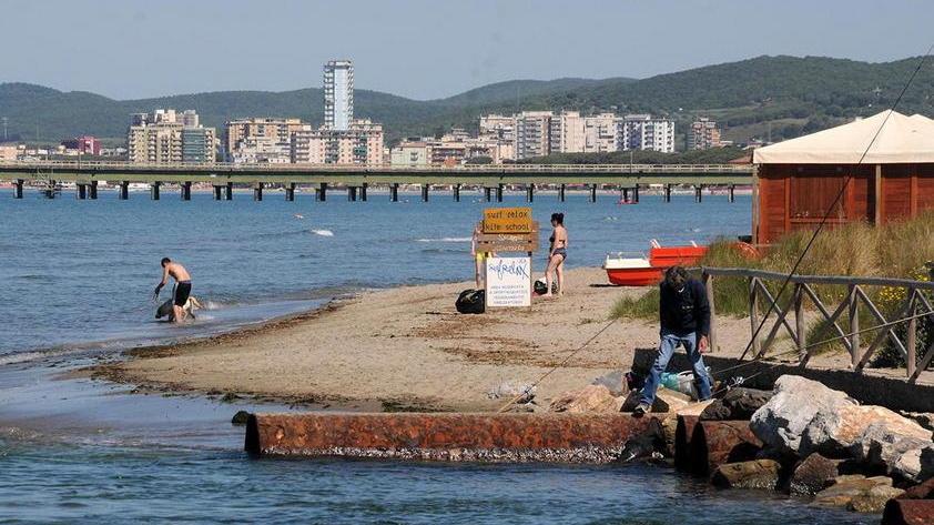 Chi va in acqua con il cane e chi pesca alla foce del canale industriale Solmine a Scarlino (foto Giorgio)