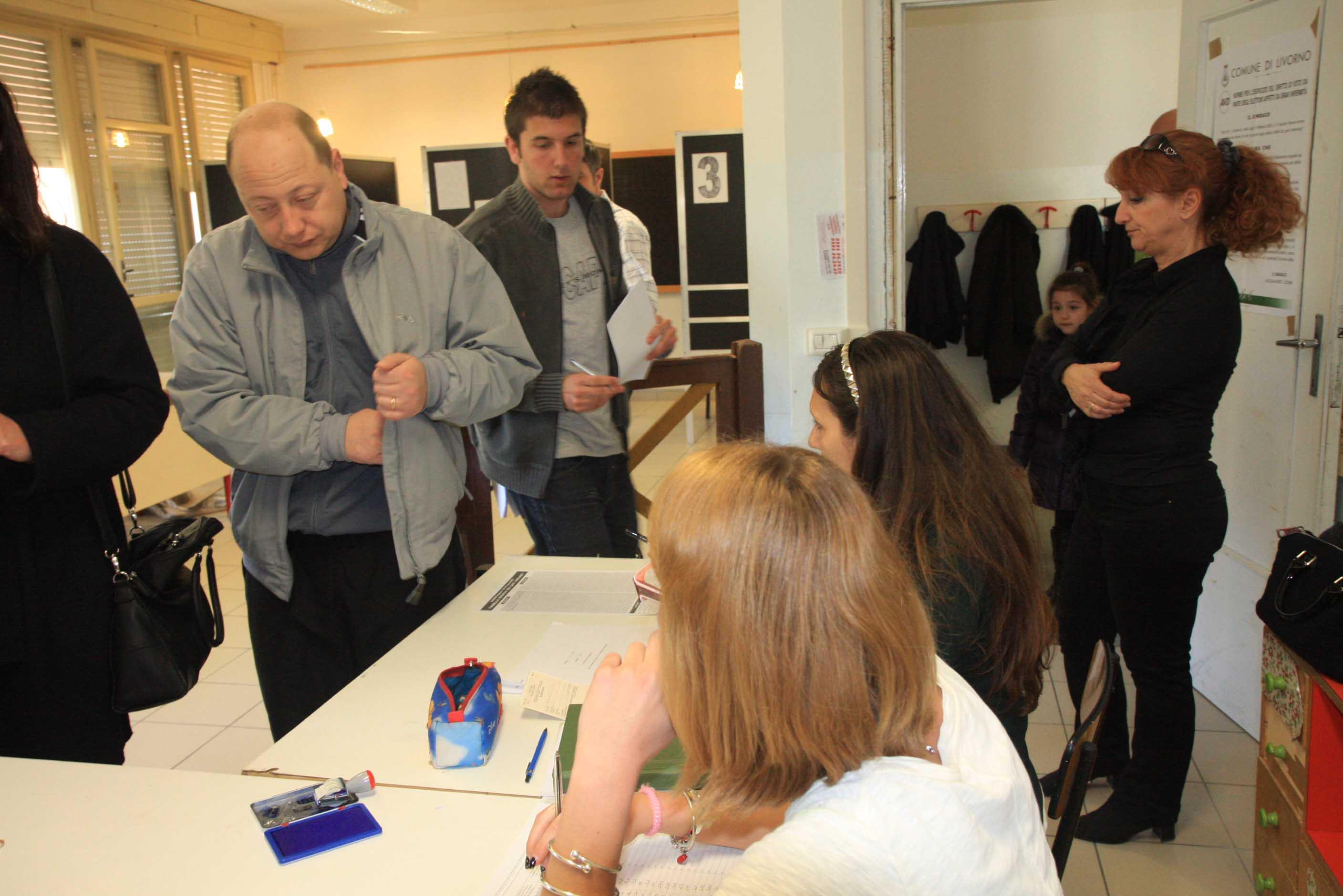 Elettori in fila al seggio in attesa di votare