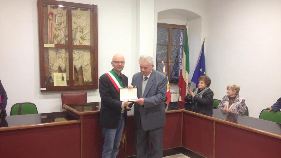 Mario Ducceschi mentre riceve un riconoscimento dal sindaco Marmo