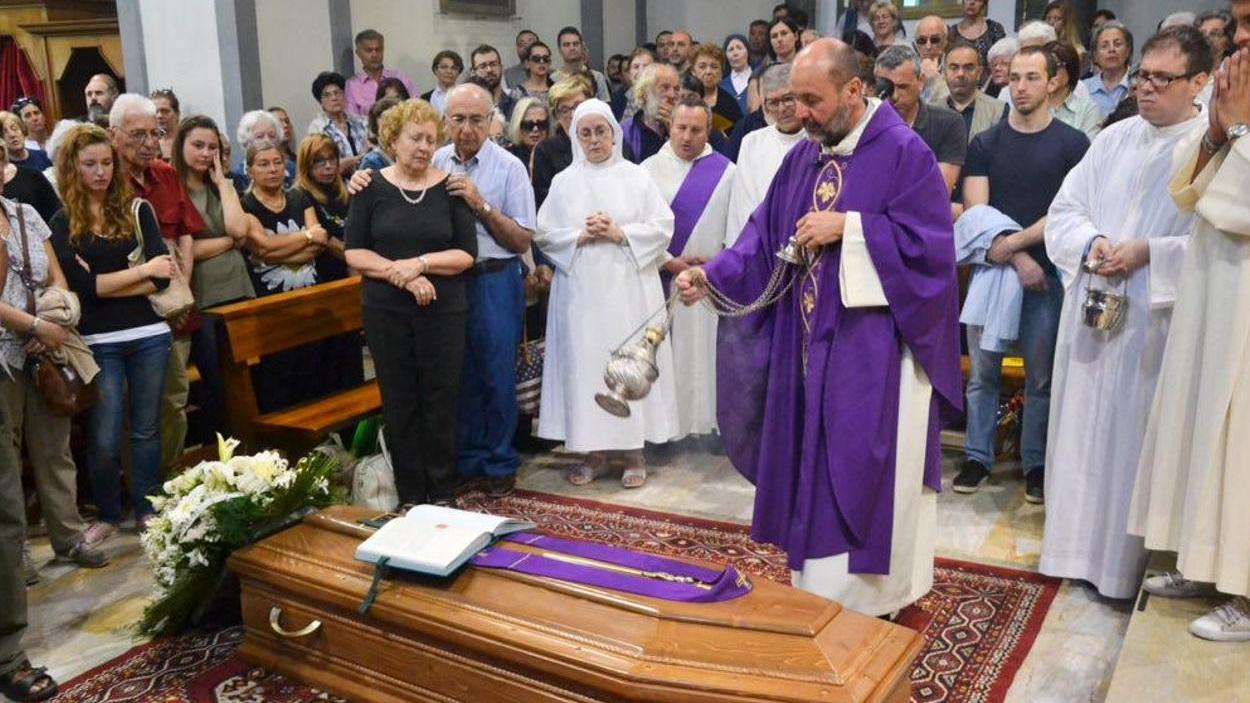Don Albizzi benedice la bara di don Carlo durante il funerale (Silvestri Pentafoto)