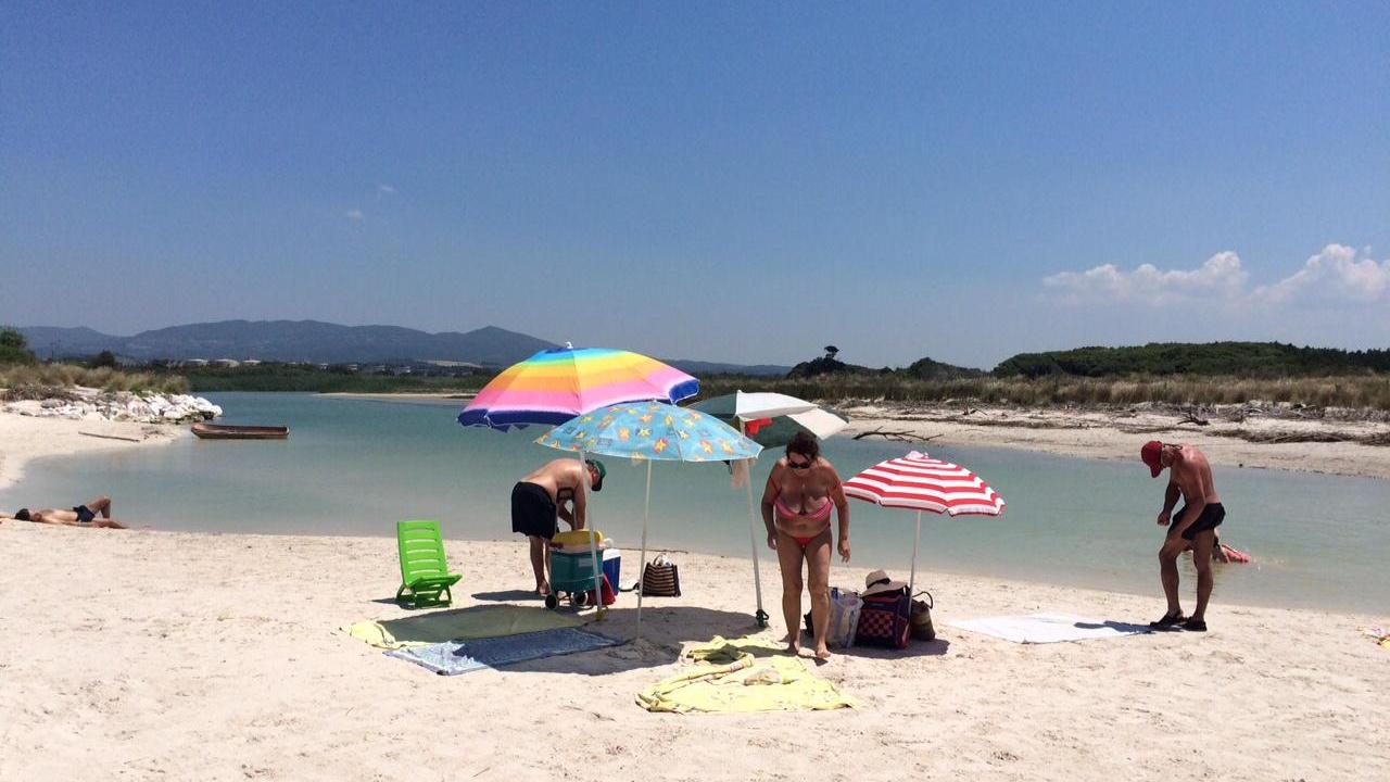Bagnanti sulla foce del Fine, alle Spiagge Bianche, dove verrà allestito il cantiere per il ripascimento (foto Falorni)