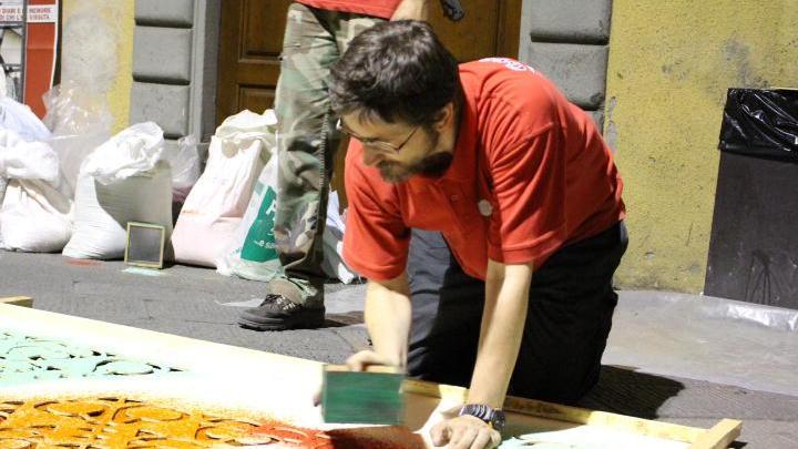 Un tappetaro al lavoro nella notte in via Vittorio Emanuele a Camaiore (foto Raffaetà)