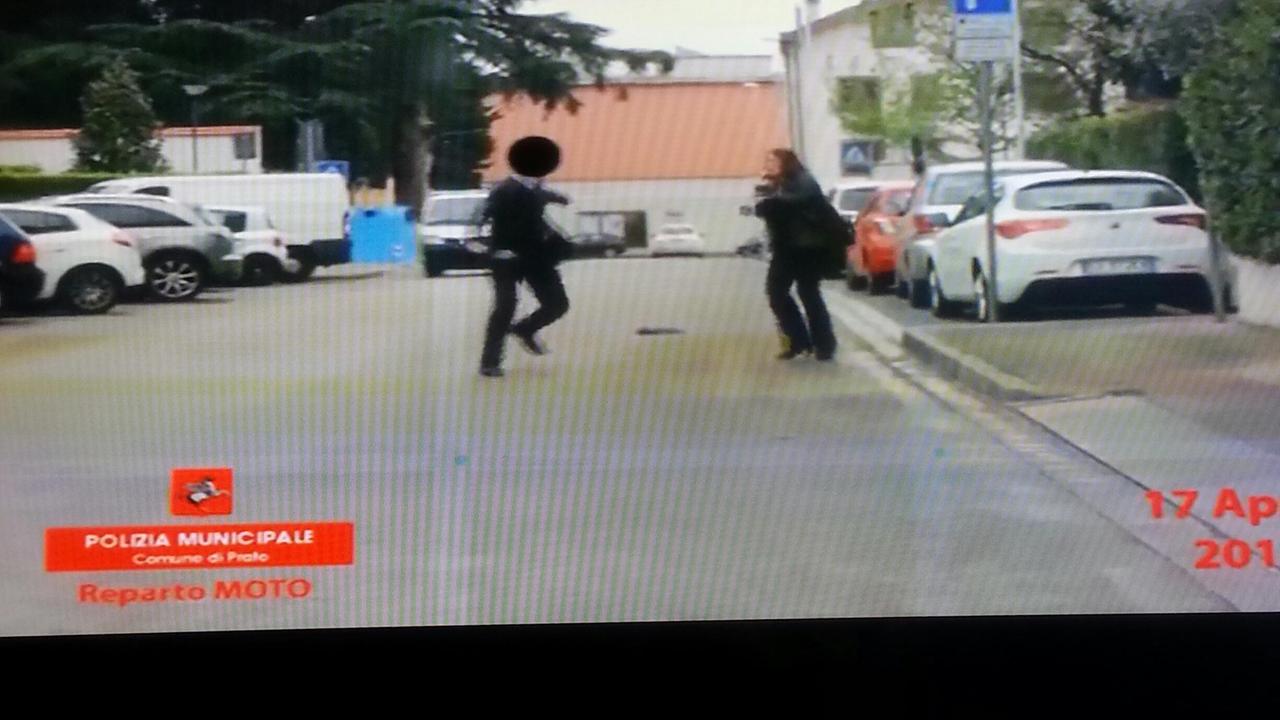Nel fotogramma del video si vede il finto cieco mentre scansa il foulard lasciato cadere dalla vigilessa