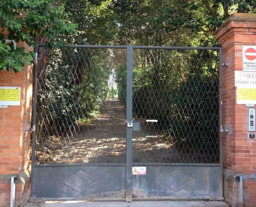 Il cancello d’ingresso a Villa Poggio Uliveto, in via della Querceta, chiuso con il lucchetto