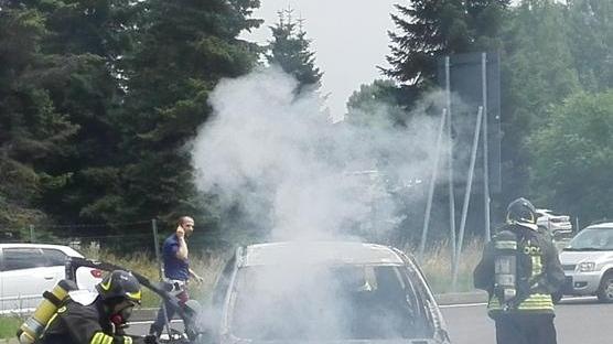 I vigili del fuoco spengono auto avvolta dalle fiamme