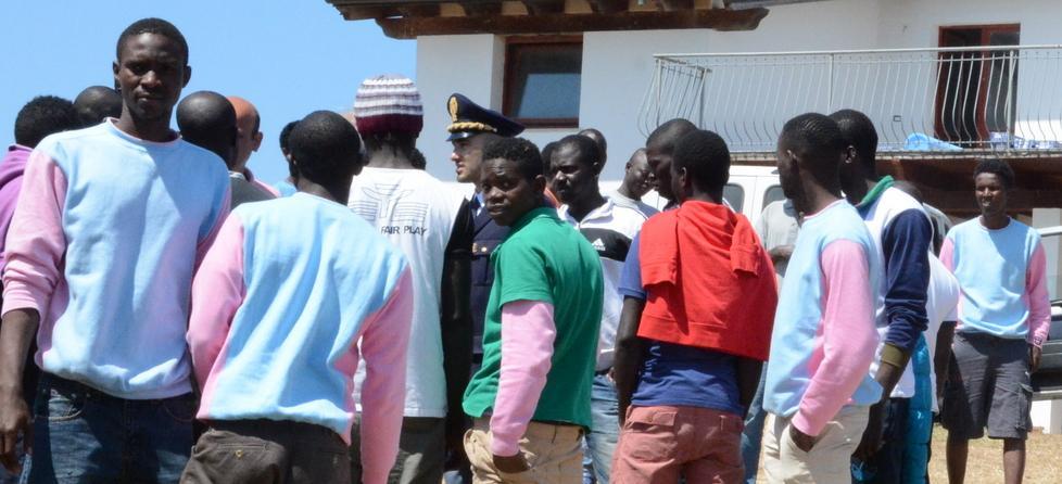 Un gruppo di migranti all'esterno dell'ex agriturismo di Palmadula (foto Mauro Chessa)