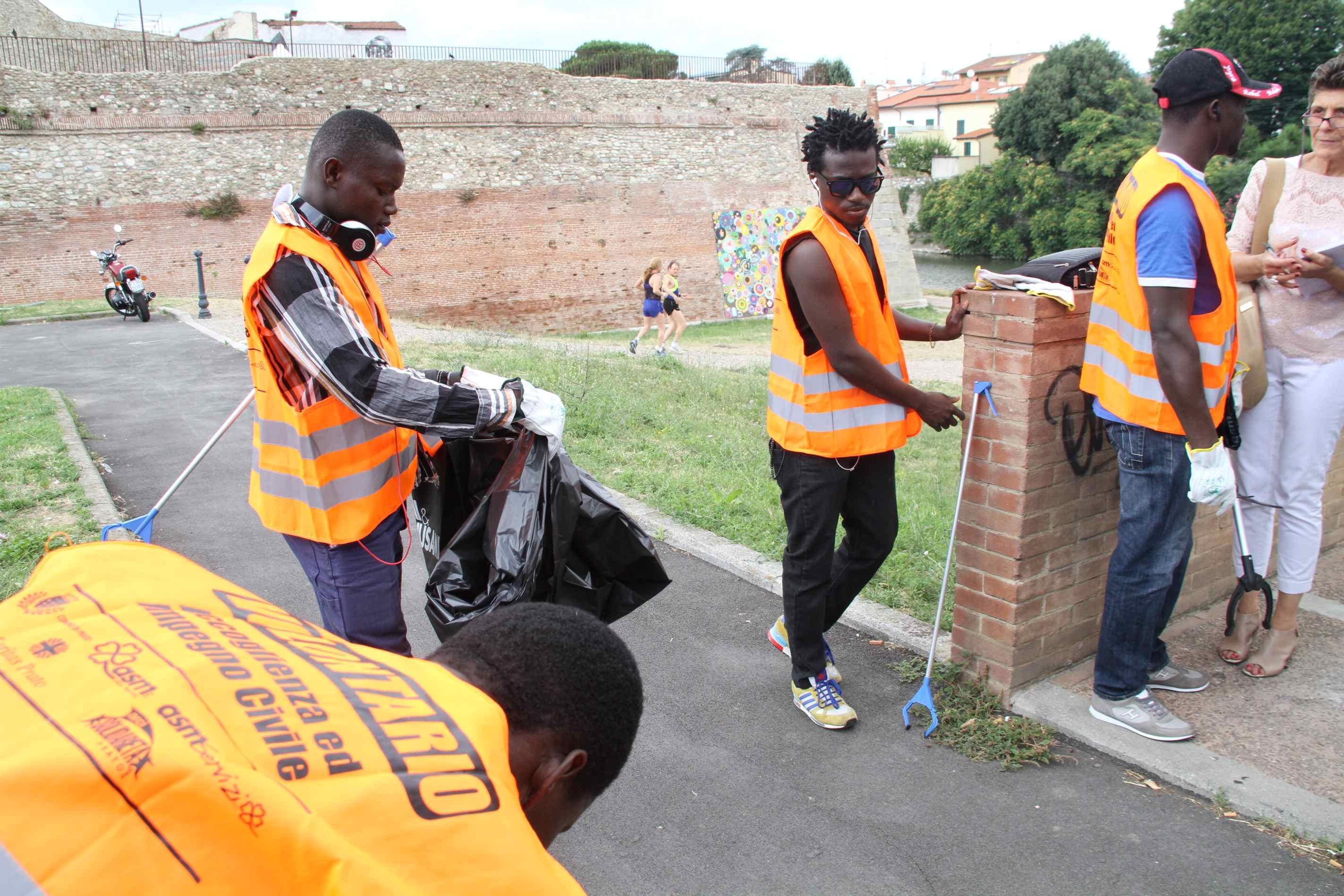 I quattro profughi fuggiti dal Ghana impiegati dal Comune nella pulizia delle piste ciclabili (foto Batavia)