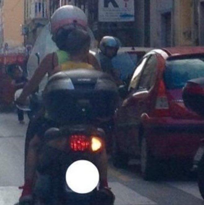 La segnalazione su fb: mamma in scooter con bimbo senza casco
