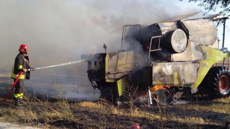 In fiamme una mietitrebbia e la vegetazione intorno