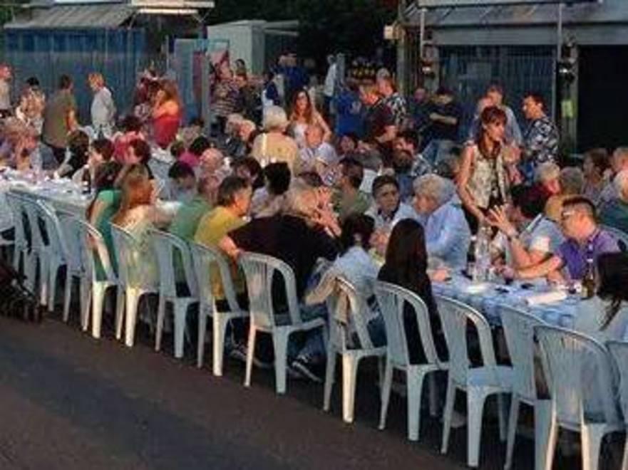 Tavoli e sedie in strada per la cena tra vicini 