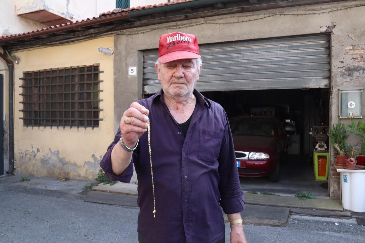 La vittima dell'aggressione mostra la catenina che è riuscito a recuperare (Marzi/Pentafoto)