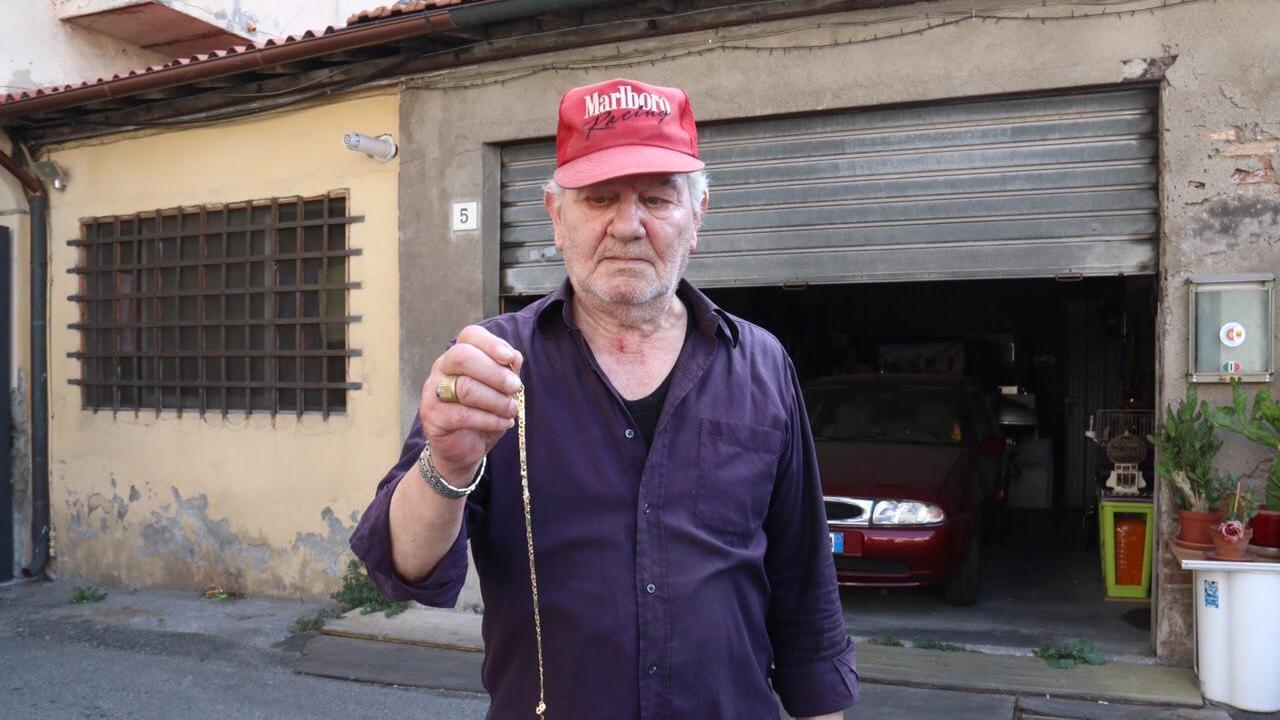 La vittima dell'aggressione mostra la catenina che è riuscito a recuperare (Marzi/Pentafoto)