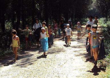 I bambini puliscono la pineta della colonia 