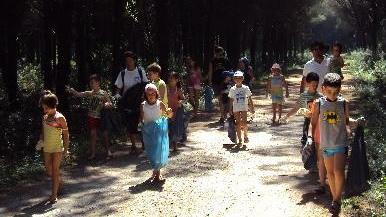 I bambini puliscono la pineta della colonia