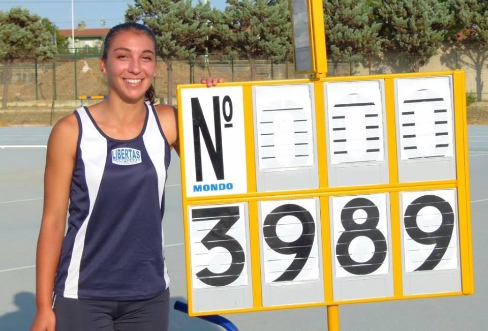 Giulia Gramignano accanto al tabellone con il nuovo record sardo del giavellotto