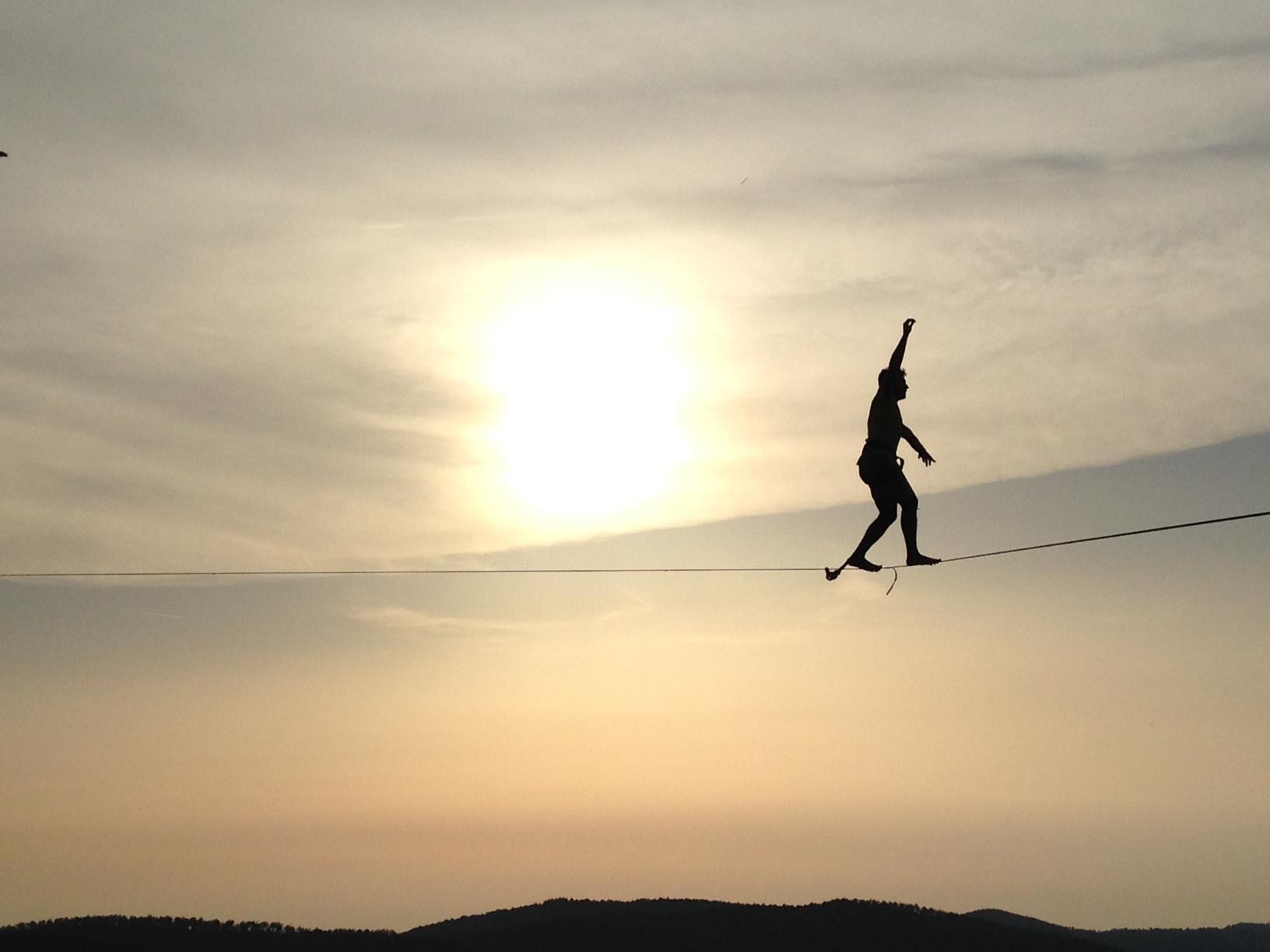 Un equilibrista attraversa sulla corda il precipizio tra i massi di Roccatederighi