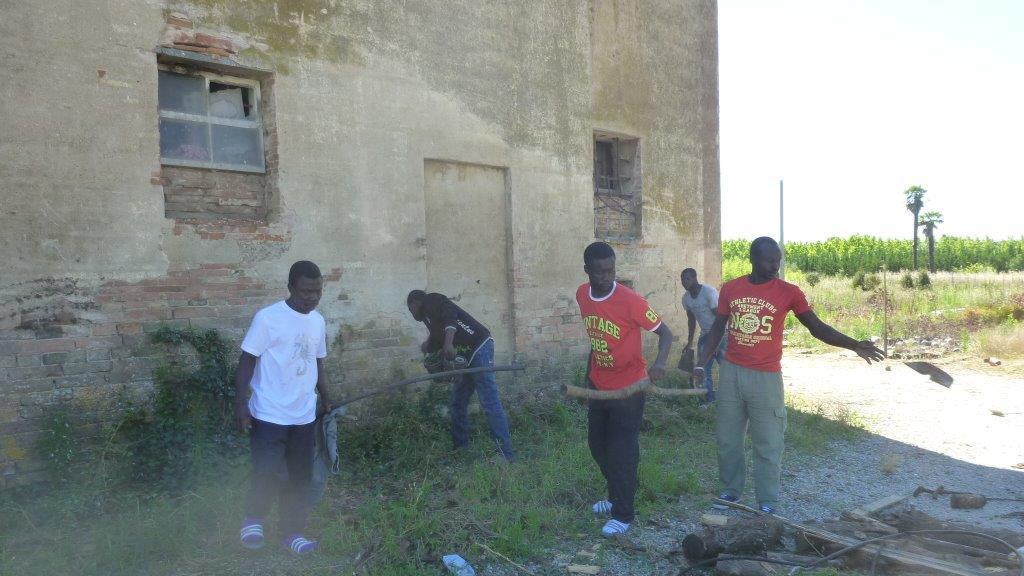 Alcuni dei migranti impegnati nella pulizia del casolare