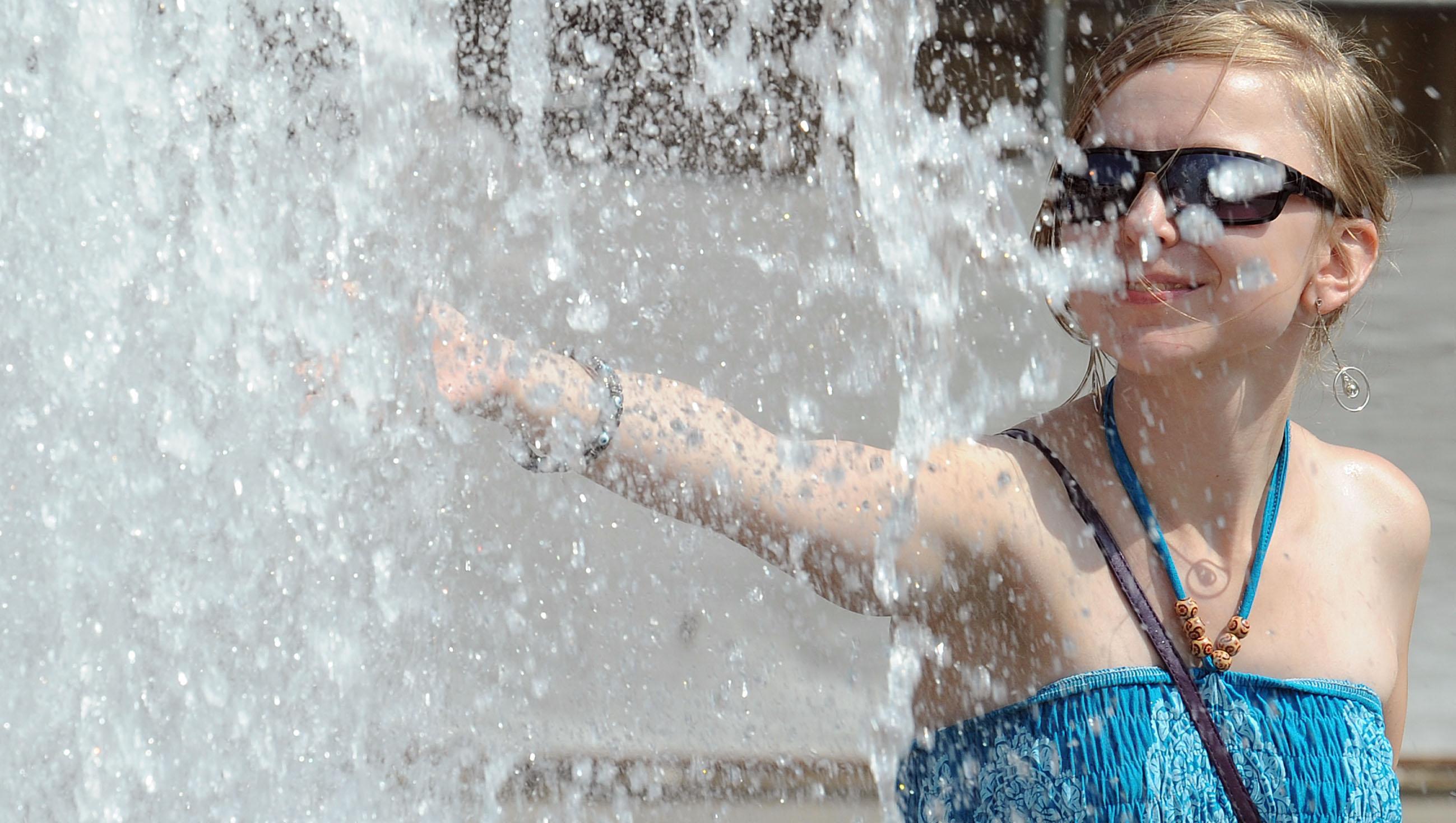 Una ragazza cerca refrigerio in una fontana