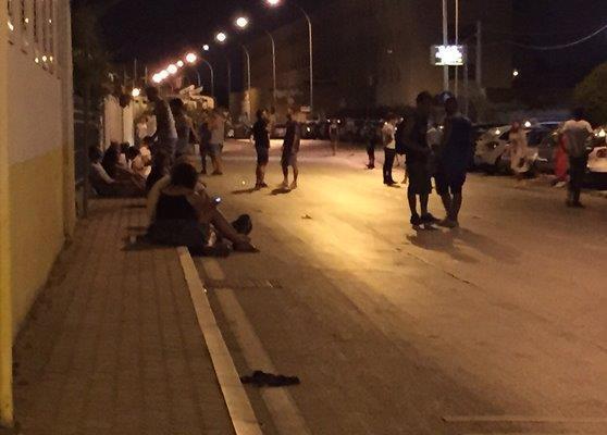 Ragazzi seduti sui marciapiedi a notte fonda a Marina di Massa