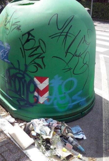 Campana del vetro stracolma degrado nella via dei bagni