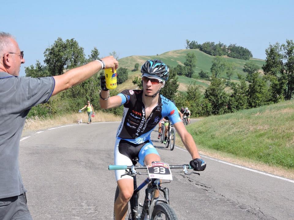 Simone Pardini durante una corsa mentre riceve la borraccia dal babbo Roberto
