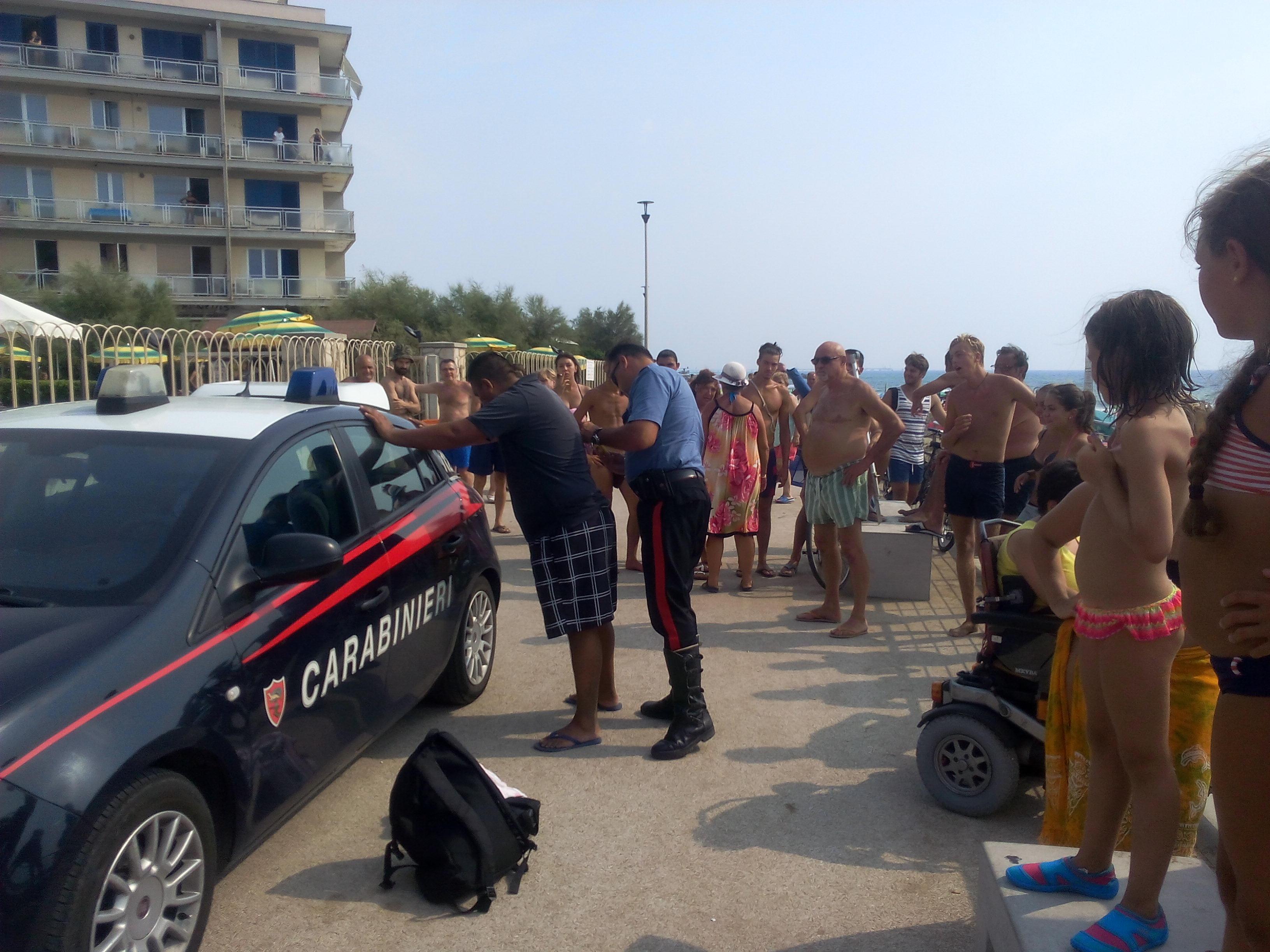 I carabinieri mentre fermano una delle persone bloccate dai bagnanti