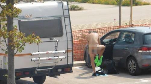 Un uomo si denuda completamente per mettersi il costume