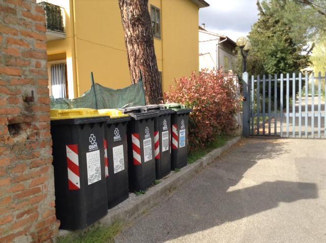 Cassonetti per la raccolta differenziata fuori da un condominio