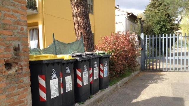 Cassonetti per la raccolta differenziata fuori da un condominio