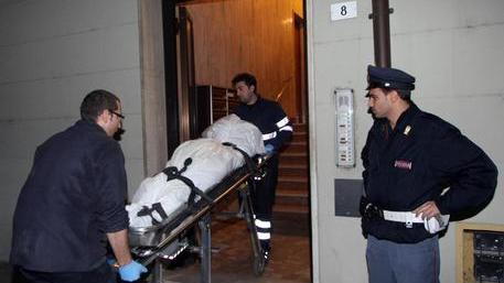 Il cadavere della donna viene portato via dall'abitazione