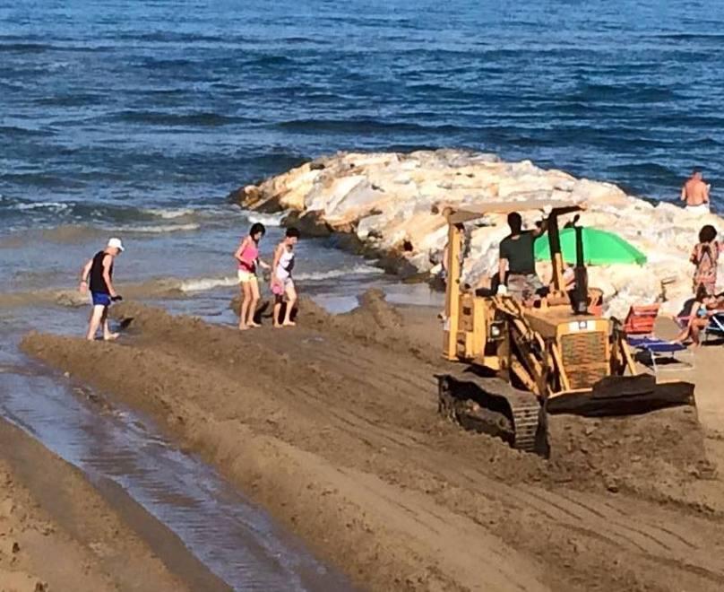 Cantiere volante in spiaggia una ruspa tra i bagnanti 