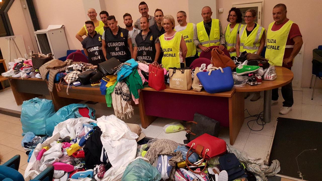 La polizia municipale con la guardia di finanza mostra la merce sequestrata dopo l’operazione di mercoledì notte alla Mazzanta