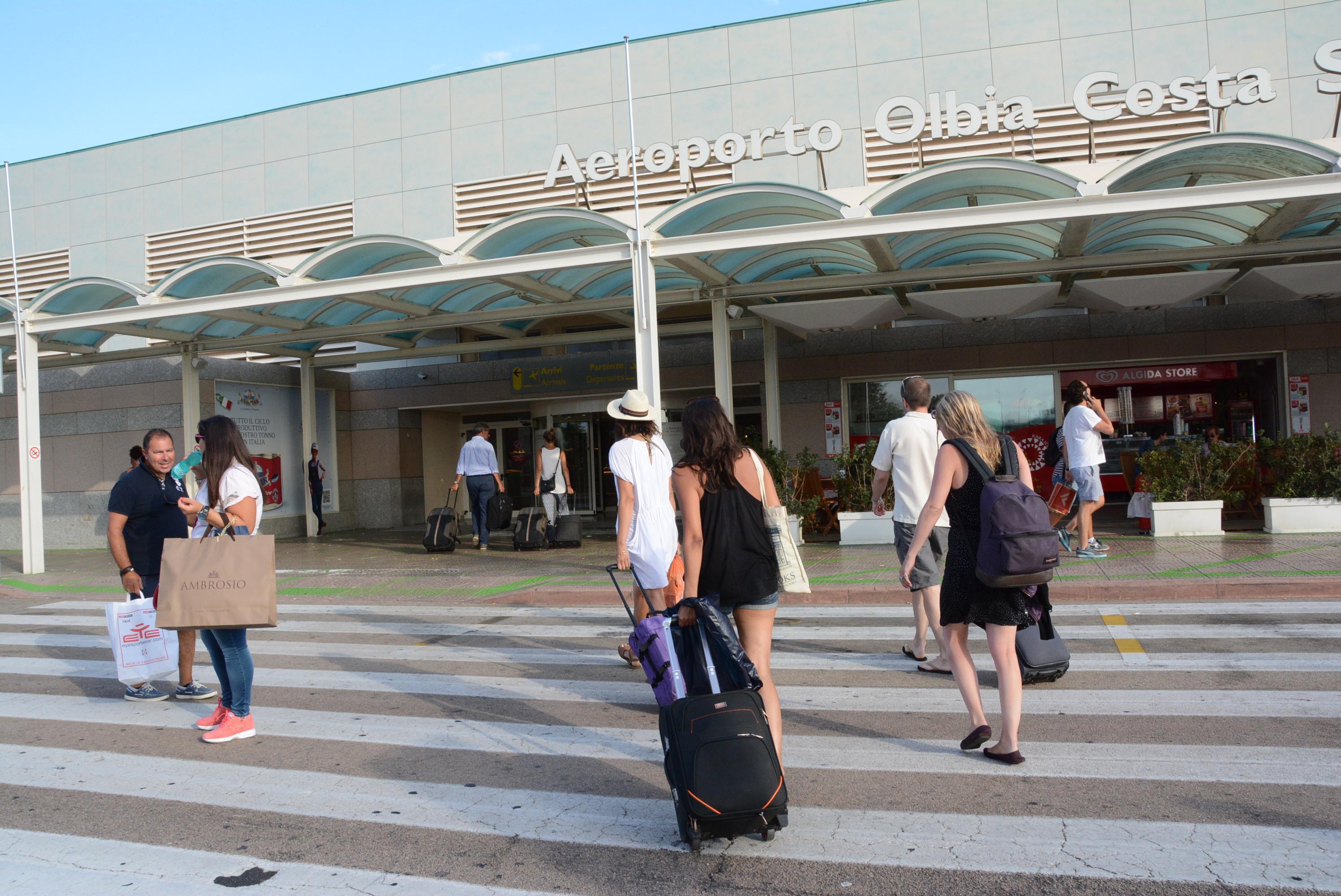 Turisti arrivano all'aeroporto di Olbia per prendere il volo che li riporterà a casa