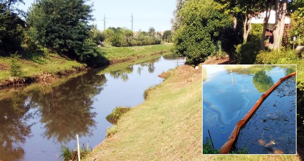 Uno dei tratti del fiume Morto inquinato dal gasolio e una delle barriere sistemate dai vigili del fuoco