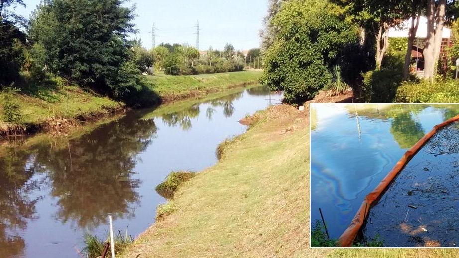 Uno dei tratti del fiume Morto inquinato dal gasolio e una delle barriere sistemate dai vigili del fuoco
