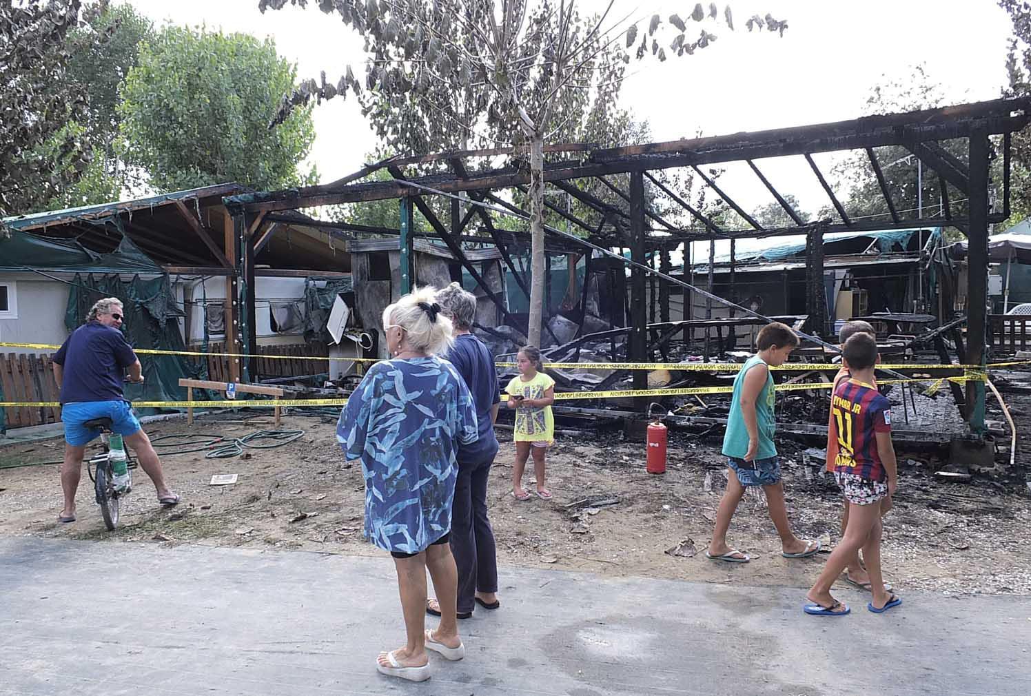 Alcuni villeggianti davanti al bungalow bruciato